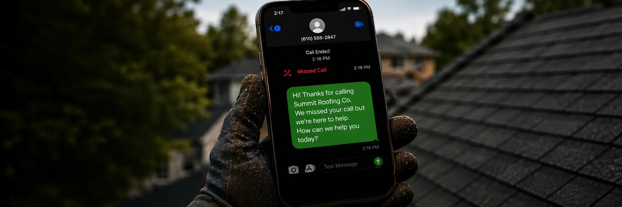 A roofer in work gloves holding a phone that shows a missed call followed by an automatic text reply from the business