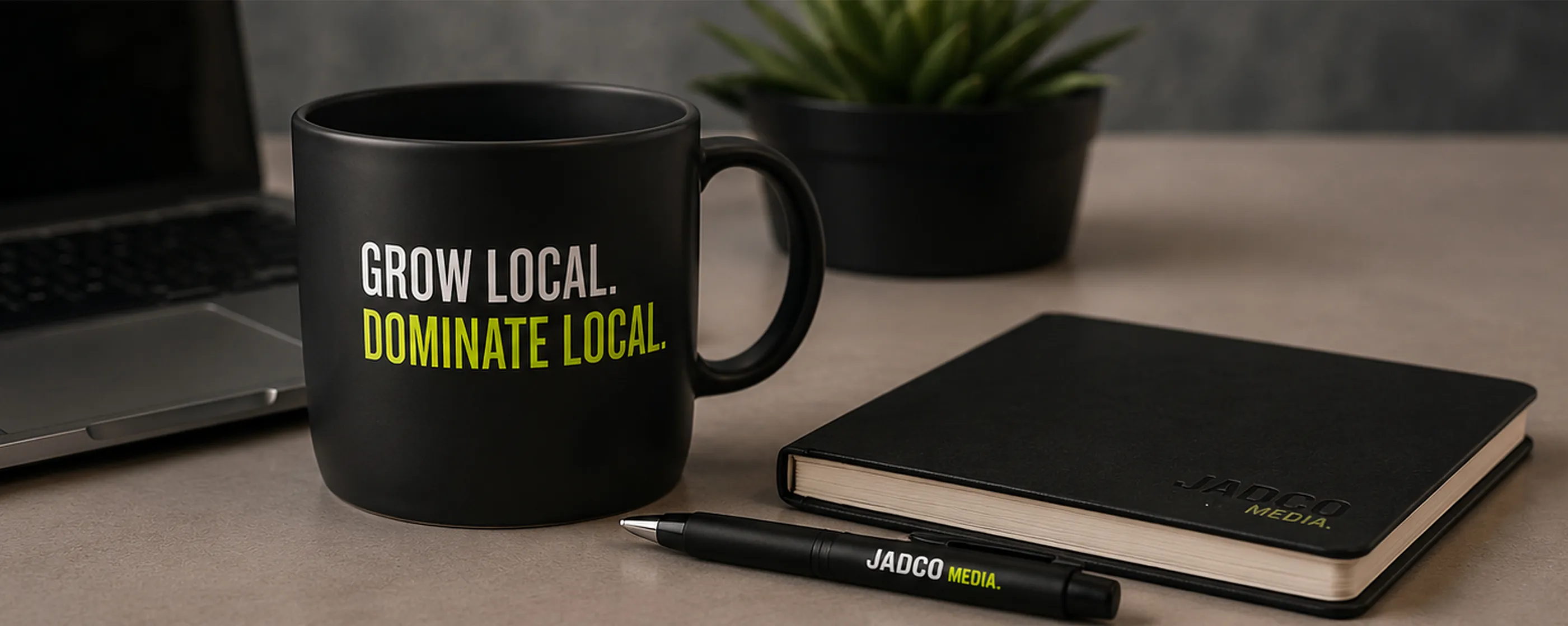 A JADCO Media branded mug and notebook on a desk